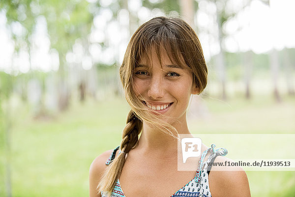 Junge Frau lächelt fröhlich im Freien  Portrait