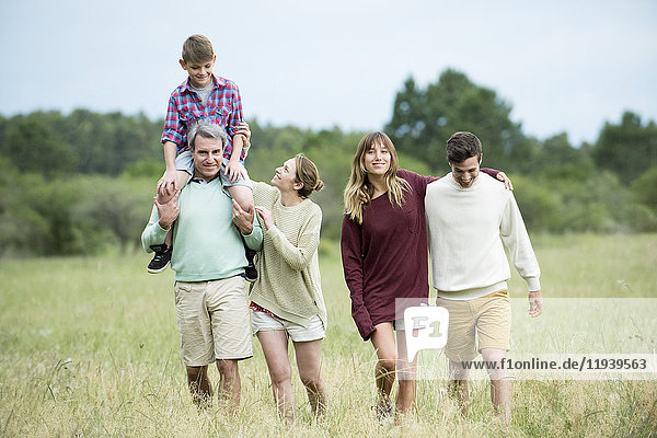 Family strolling together in field
