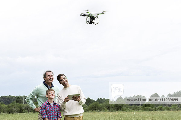 Familie mit digitalem Tablett zur Steuerung von Drohnen im Freien