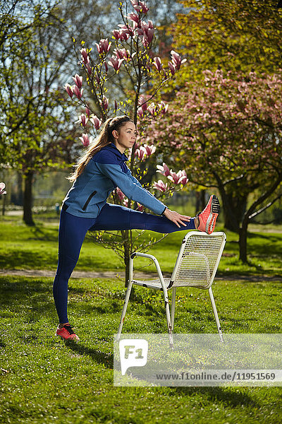 Sportliche Frau dehnt sich in einem Park im Frühling