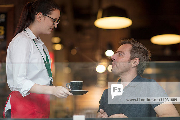Waitress serving customer coffee