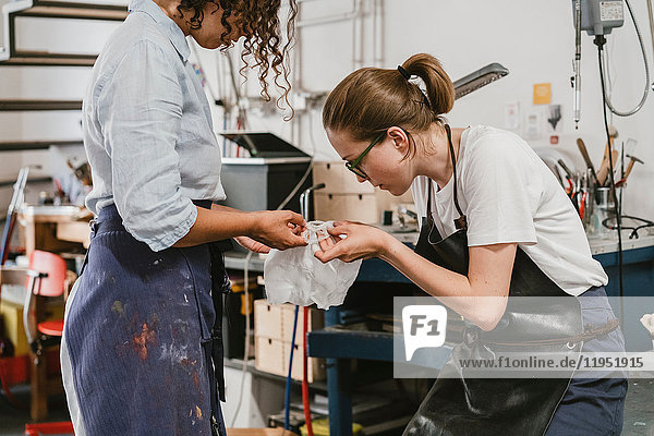 Juwelierinnen inspizieren komplizierte Produkte in Schmuckwerkstatt