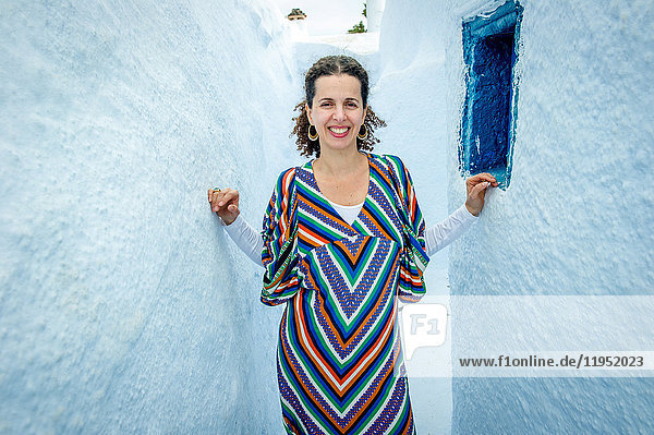 Woman standing in narrow gap between walls  Oía  Santorini  Kikladhes  Greece