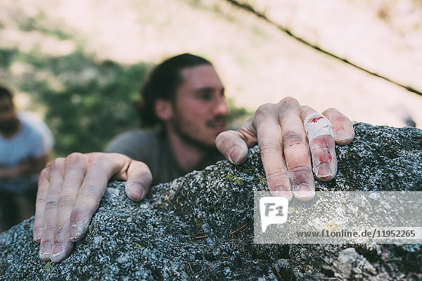 Hände eines männlichen Boulderers  der eine Felskante greift  Lombardei  Italien