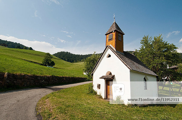 Landstraße und Kirche San Pietro  Tal von Funes  Dolomiten  Italien