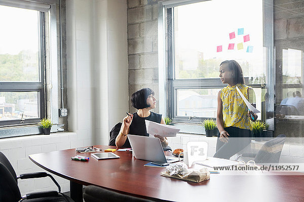 Two women working together in meeting room  brainstorming
