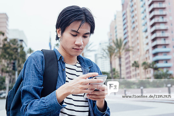 Junger Mann im Freien  benutzt Smartphone