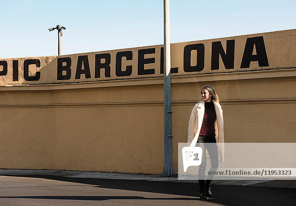 Weibliche Touristin bei einem Mauerspaziergang mit Barcelona in Großbuchstaben,  Barcelona,  Spanien