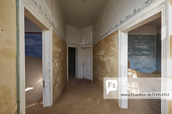 Ein Blick auf Räume in einem heruntergekommenen Gebäude voller Sand.