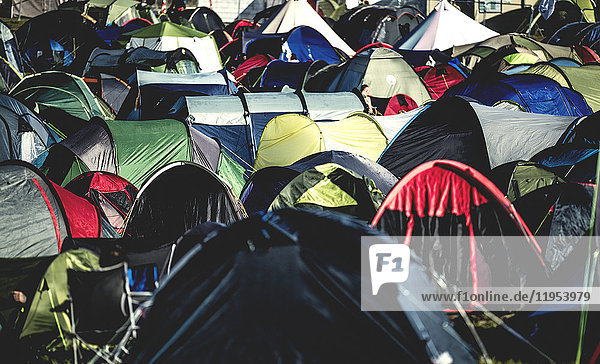 Zelte auf dicht gedrängtem Gras  die bei einem Freiluftmusikfestival im Sommer dicht nebeneinander aufgestellt wurden. Ein voller Zeltplatz.