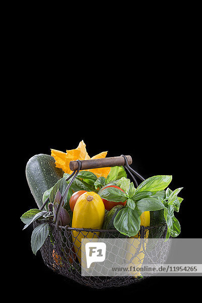 fresh garden vegetables on iron basket on a black background