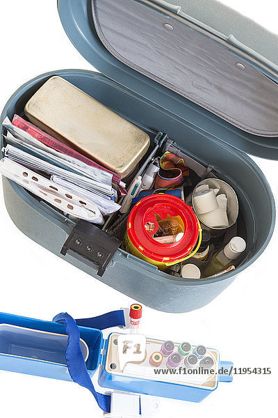 Nurse organising her First aid briefcase medical tools . Assistance equipment on white