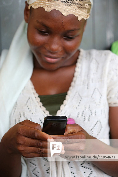 Afrikanische Frau bei der Benutzung eines Mobiltelefons. Lome. Togo.