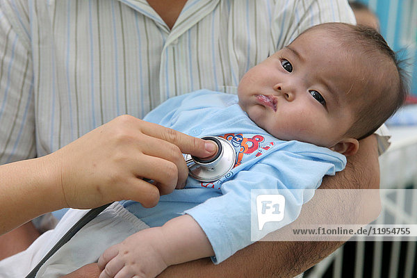 The Heart Institute offer high-quality care to Vietnamese patients suffering from heart diseases. Doctor listening to young baby's heart. Ho Chi Minh City. Vietnam.