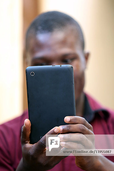 Ein afrikanischer Mann benutzt ein Smartphone. Lome. Togo.