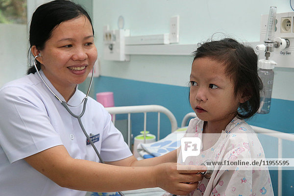 Das Herzinstitut bietet vietnamesischen Patienten  die an Herzkrankheiten leiden  eine hochwertige Versorgung. Ein Arzt hört sich das Herz eines jungen Mädchens an. Ho-Chi-Minh-Stadt. Vietnam.