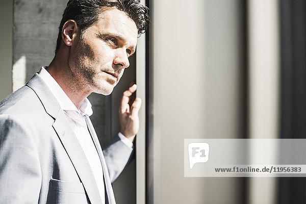 Portrait of a businessman  looking out of winsow