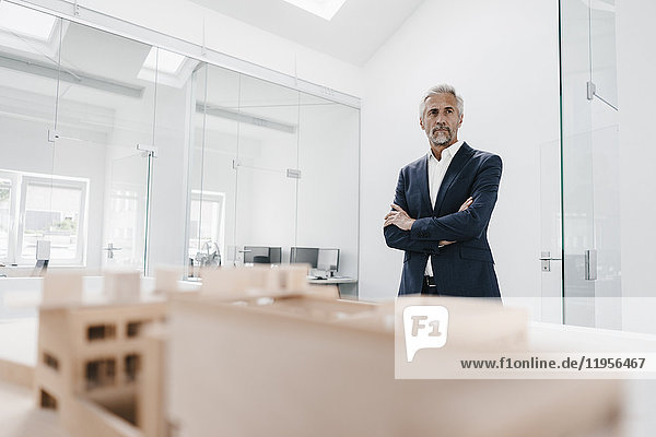 Mature businessman with architectural model in office