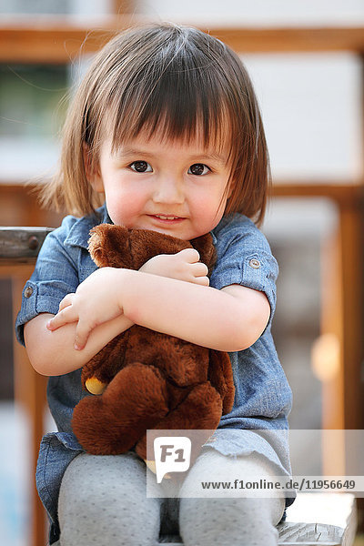 Gemischtrassiges junges Mädchen mit Teddybär