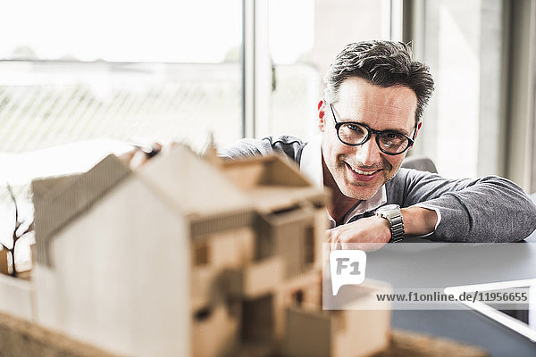 Portrait of smiling architect working on architectural model