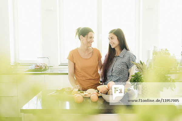 Zwei lächelnde Frauen in der Küche beim Zubereiten von Obst