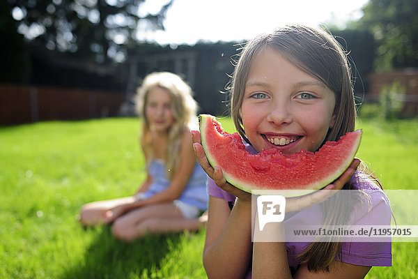 Happy girl with a water melon in garden