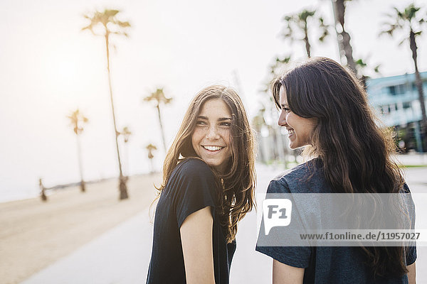 Zwei glückliche junge Frauen an der Strandpromenade