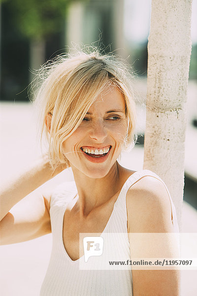 Portrait of laughing blond woman watching something