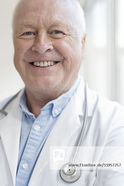 MODEL RELEASED. Senior male doctor smiling towards camera.