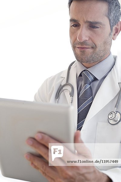 MODELL FREIGEGEBEN. Männlicher Arzt mit digitalem Tablet.