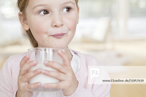 Junges Mädchen trinkt ein Glas Milch.