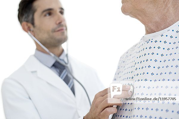 MODEL RELEASED. Male doctor examining senior patient  portrait.