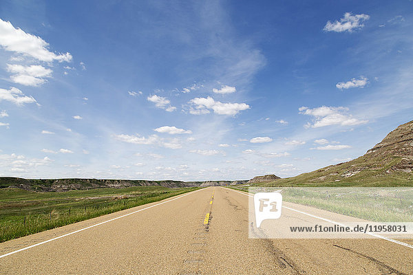 Blue sky over a highway through the Badlands of Alberta near Drumheller Alberta Canada North America