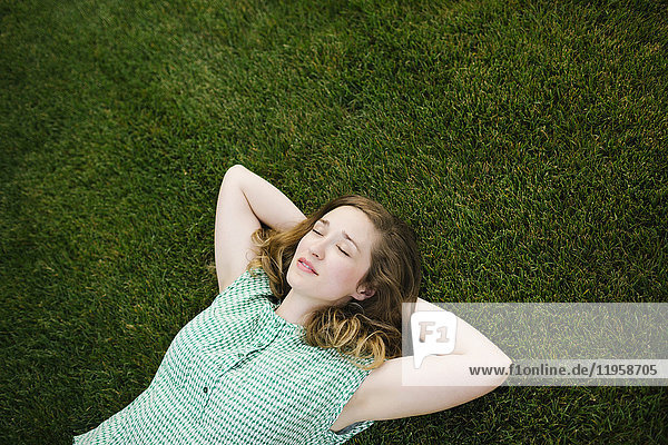 Frau liegt im Gras und schläft