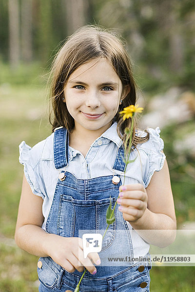 Porträt eines Mädchens (8-9) mit Wildblumen in der Hand