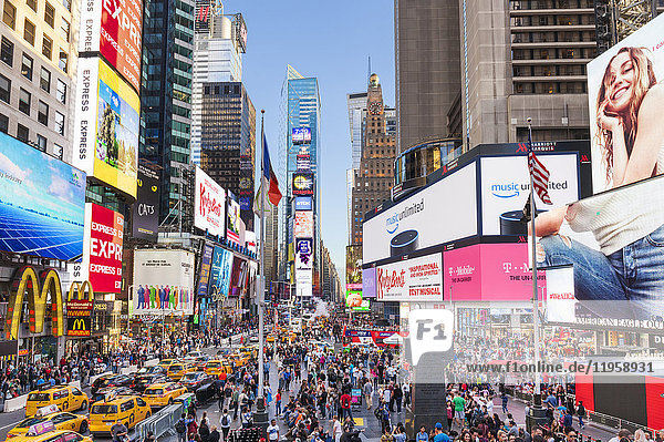 Crowds with busy traffic yellow cabs Times Square and Broadway Theatre District Manhattan New York City United States of America North America