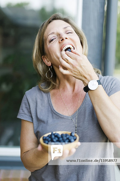 Frau isst Blaubeeren