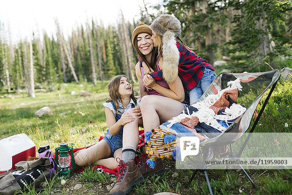 Mother with son (6-7) and daughter (8-9) camping in forest