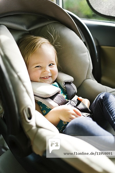 Baby-Mädchen (12-17 Monate) sitzt während der Autofahrt in der Babyschale