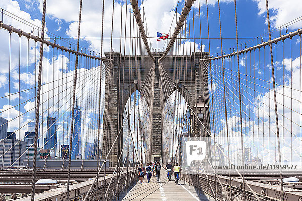 Tourists  cyclists on walkway  Brooklyn Bridge  Lower Manhattan skyline  New York skyline  New York City  United States of America  North America