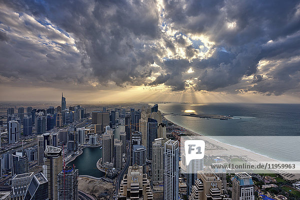 Stadtbild von Dubai  Vereinigte Arabische Emirate unter bewölktem Himmel  mit Wolkenkratzern und der Küstenlinie des Persischen Golfs.