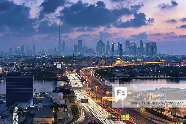 Stadtbild von Dubai  Vereinigte Arabische Emirate in der Abenddämmerung  mit der Autobahn über den Jachthafen und Wolkenkratzern in der Ferne.