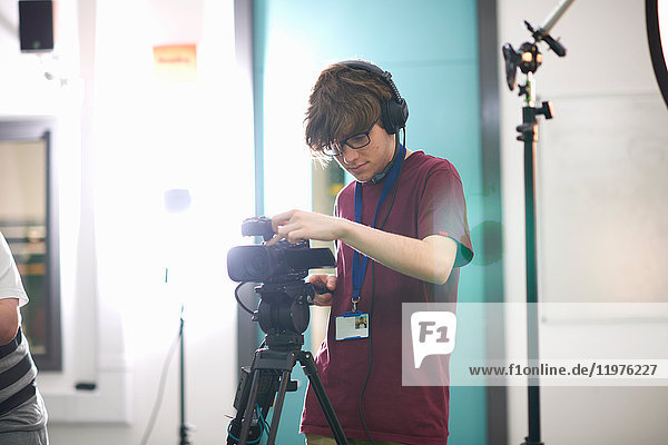 Young male college student filming in TV studio