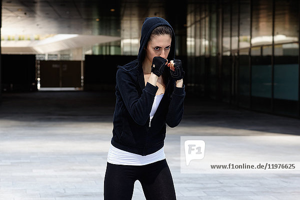Young woman outdoors  exercising  in fighting stance