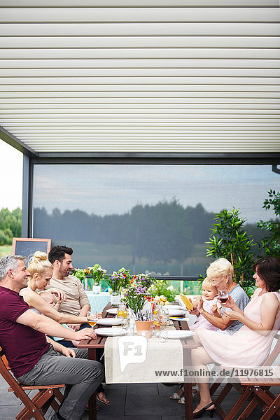 Three generation family having family lunch on patio