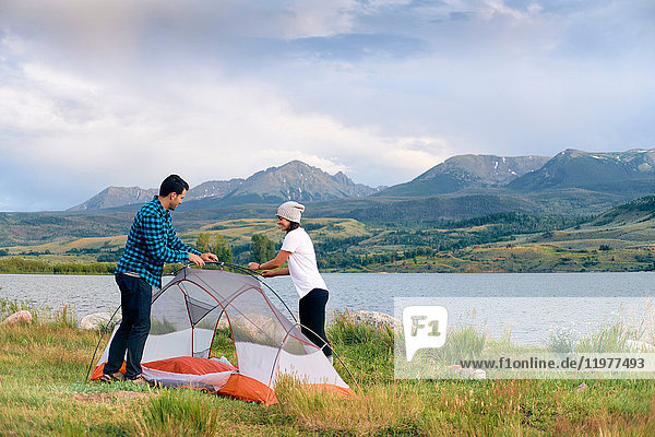 Couple in rural setting  putting up tent  Heeney  Colorado  United States