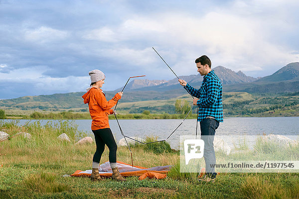 Couple in rural setting  putting up tent  Heeney  Colorado  United States