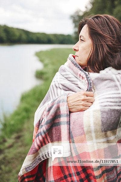 Mature woman in rural setting  wrapped in blanket