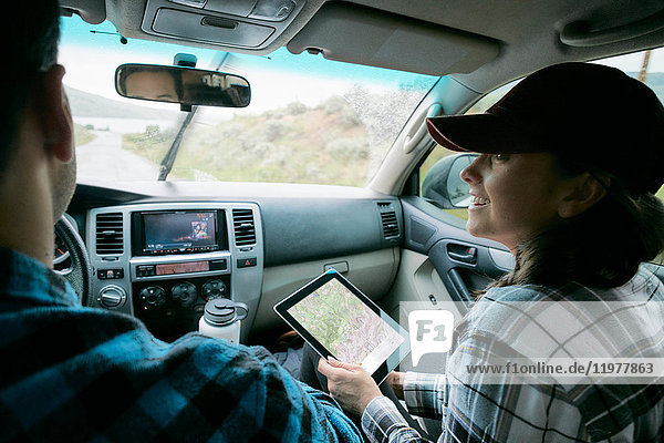 Ehepaar im Auto  Frau hält digitales Tablett mit Karte in der Hand