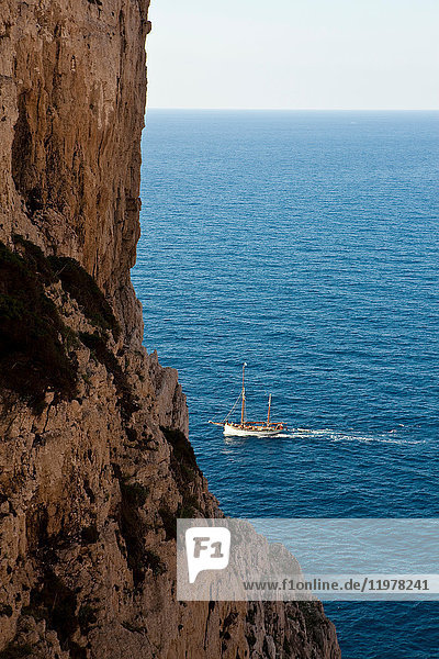 Scenic view of coastal cliffs and boat,  Capo Caccia,  Sardinia,  Italy